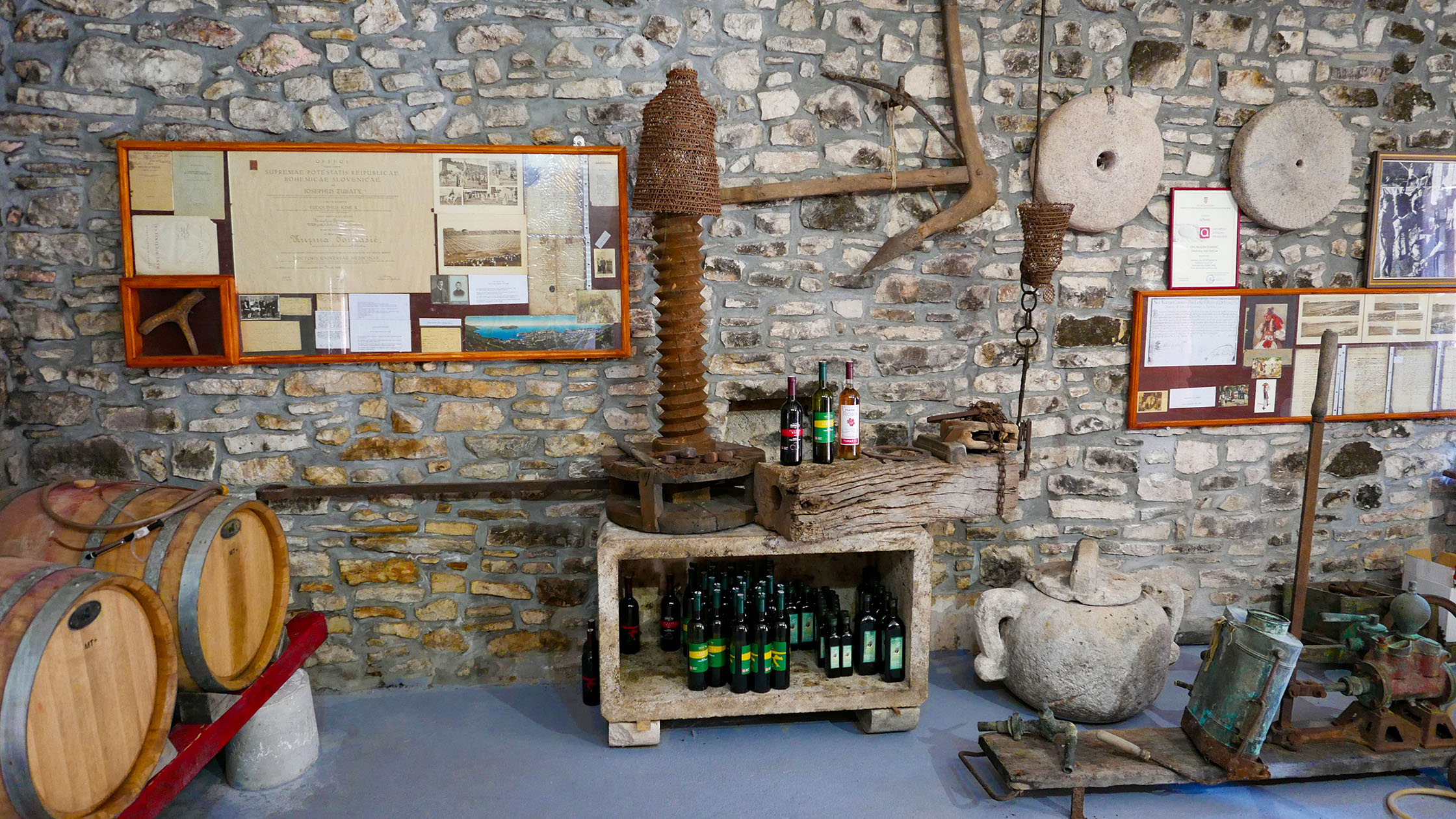 The stone cellar at Smokvica with a wicker press at its centre and documents on the walls