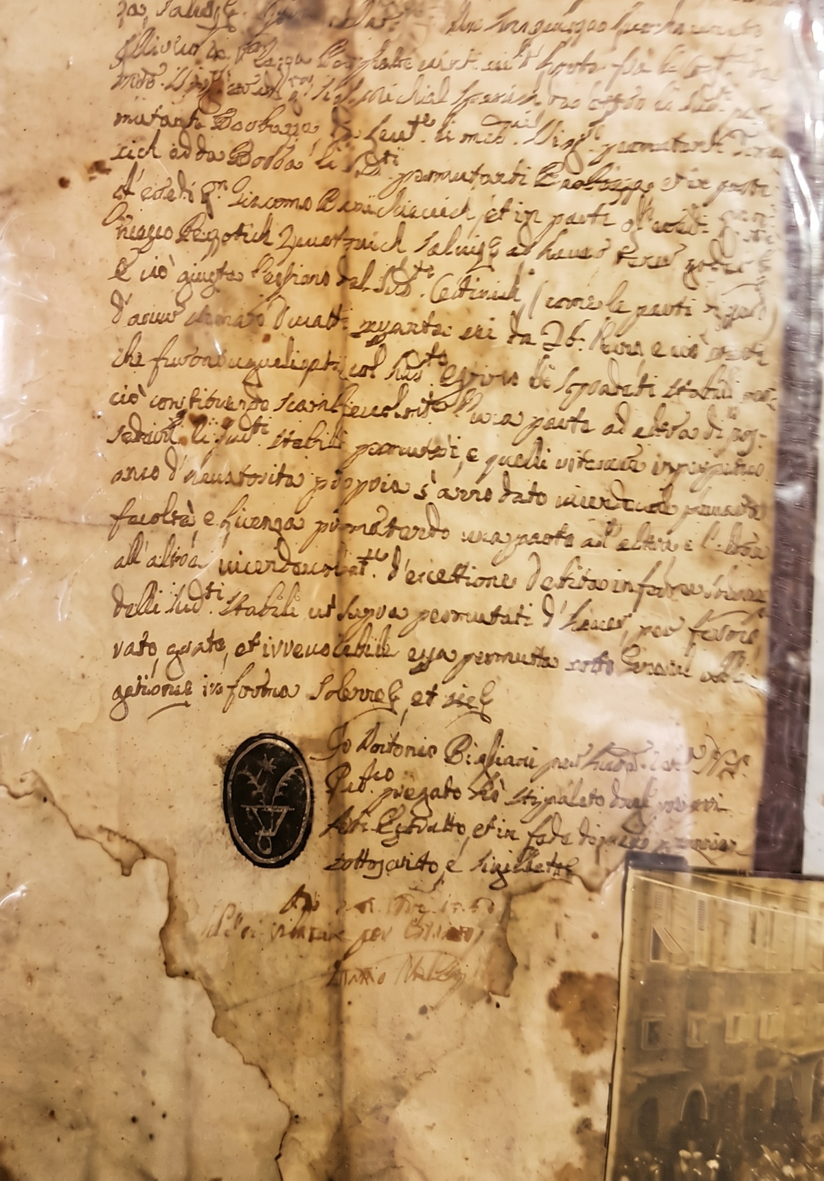 The burnt 1753 notarial parchment with the oval flower-from-a-vessel seal pressed in ink near the foot