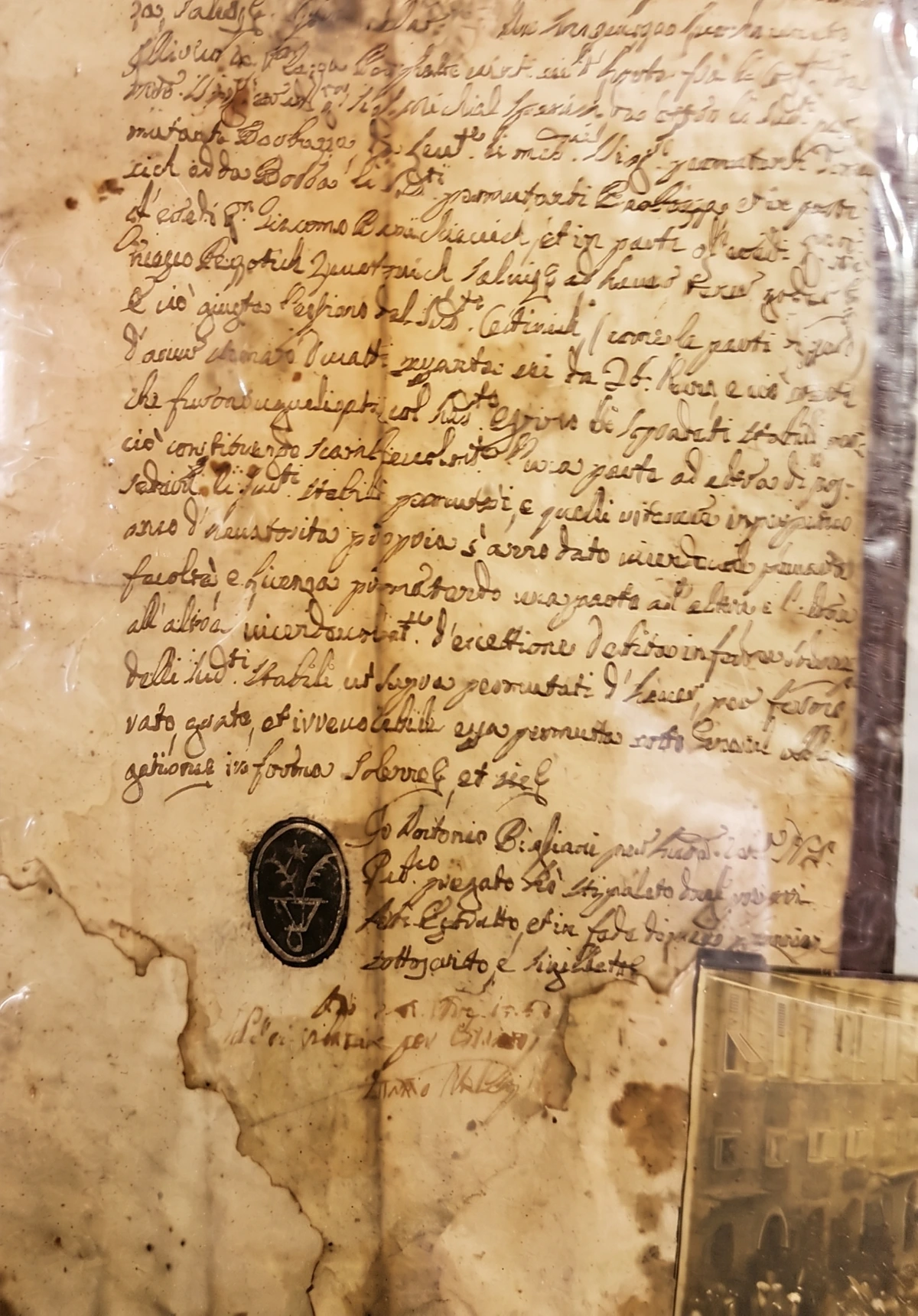 The burnt 1753 notarial parchment with the oval flower-from-a-vessel seal pressed in ink near the foot